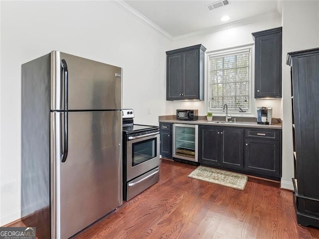 kitchen featuring sink, beverage cooler, dark hardwood / wood-style flooring, ornamental molding, and stainless steel appliances