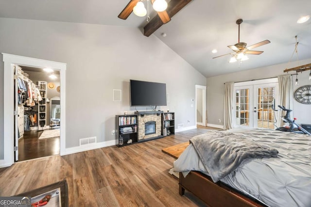 bedroom with access to outside, french doors, a fireplace, beamed ceiling, and dark hardwood / wood-style flooring