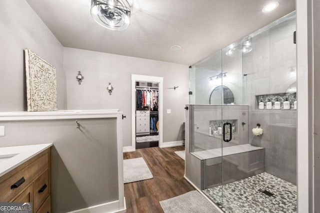 bathroom with wood-type flooring, an enclosed shower, and vanity