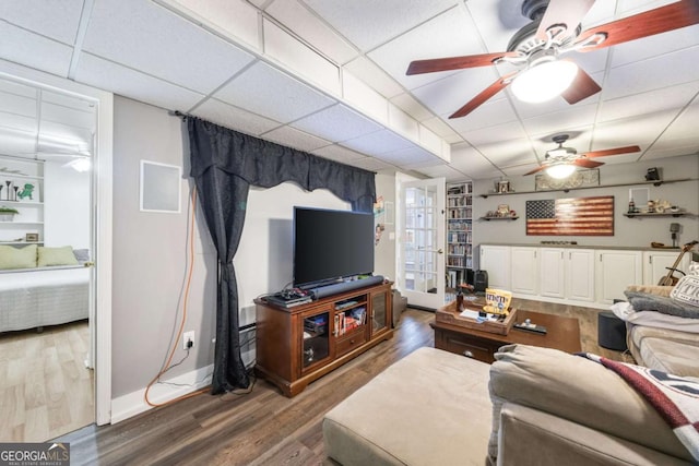 living room with ceiling fan, a paneled ceiling, and hardwood / wood-style floors