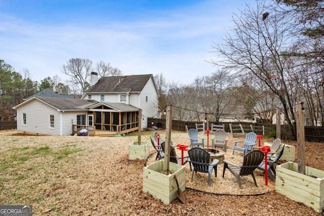 back of property featuring an outdoor fire pit and a sunroom