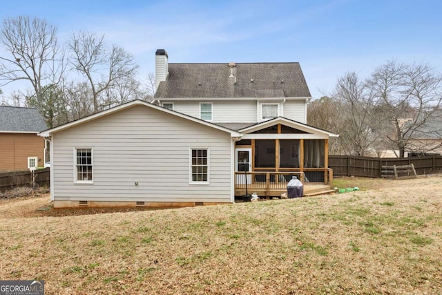 back of property with a lawn, a wooden deck, and a sunroom