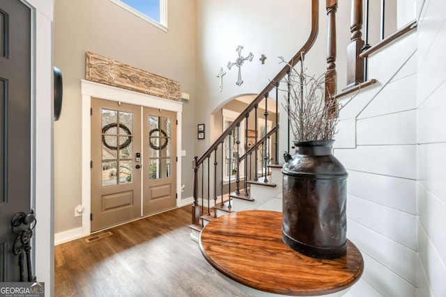 entrance foyer featuring a towering ceiling and hardwood / wood-style floors