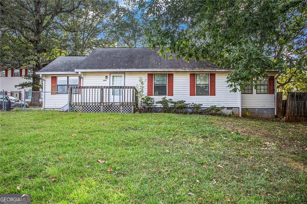 ranch-style home with a wooden deck and a front lawn