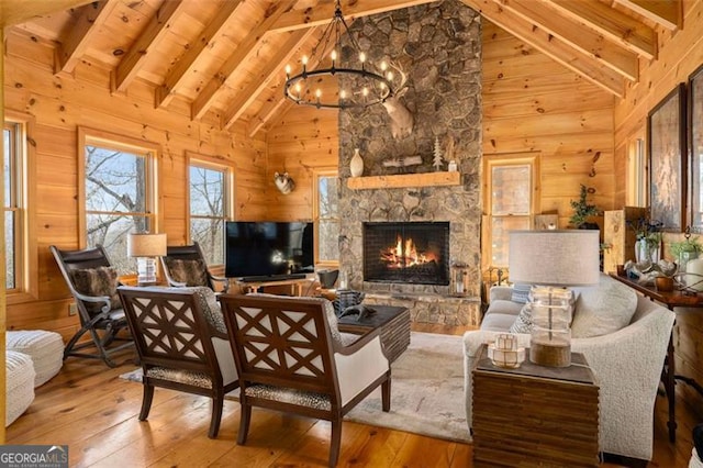 851 Moreland Dr N, Blue Ridge, GA 30513 - living room featuring a stone fireplace, beam ceiling, wood-type flooring, a chandelier, and wooden walls