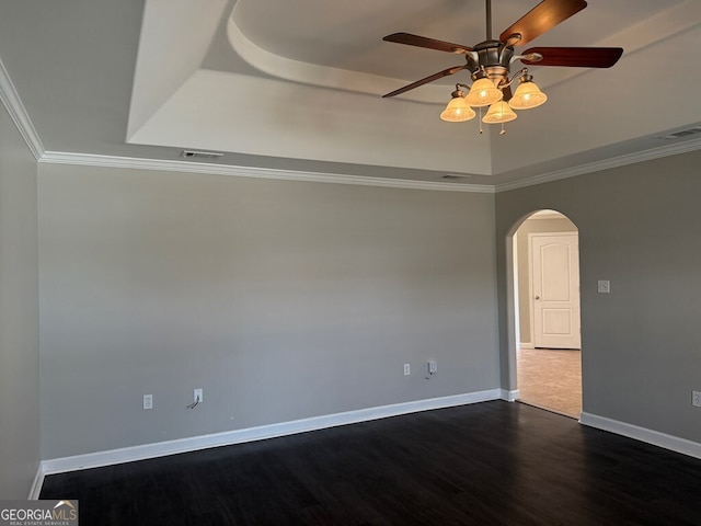 spare room with crown molding, ceiling fan, dark hardwood / wood-style flooring, and a tray ceiling