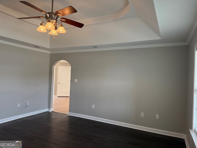 unfurnished room featuring ceiling fan, ornamental molding, dark hardwood / wood-style floors, and a raised ceiling