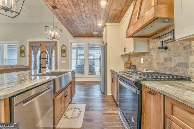 kitchen featuring premium range hood, appliances with stainless steel finishes, light stone counters, and white cabinets