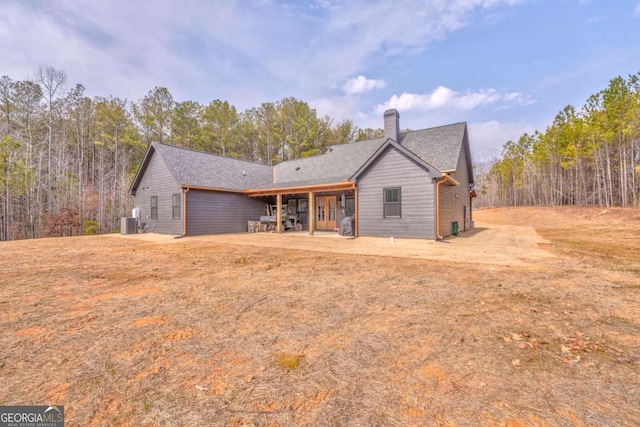 back of property featuring a lawn, central AC, and a patio area