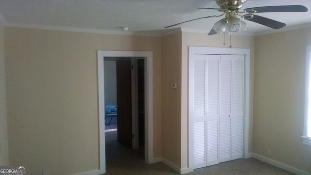 unfurnished bedroom featuring ceiling fan, ornamental molding, carpet floors, and a closet