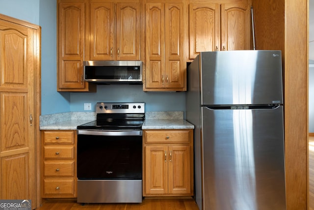 kitchen with light wood-type flooring and appliances with stainless steel finishes