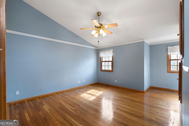 unfurnished room featuring wood-type flooring, lofted ceiling, ornamental molding, and ceiling fan