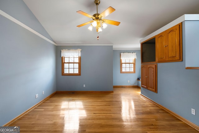 empty room featuring ceiling fan, lofted ceiling, and light wood-type flooring