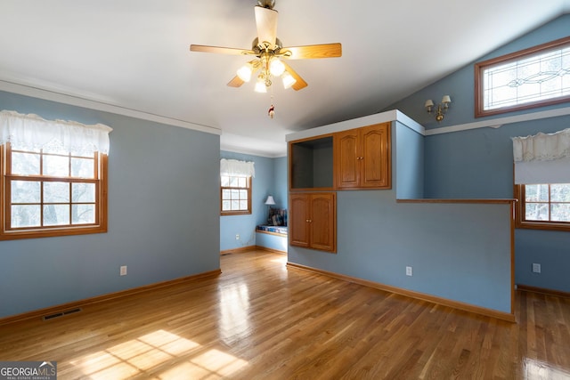 unfurnished room featuring wood-type flooring, a wealth of natural light, and ceiling fan