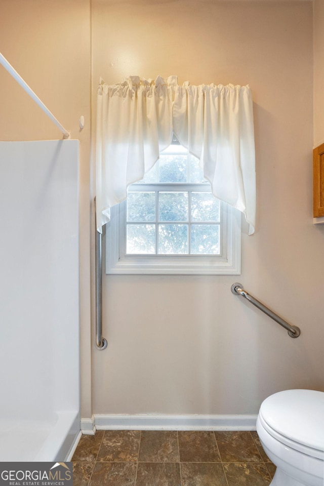 bathroom featuring a shower and toilet