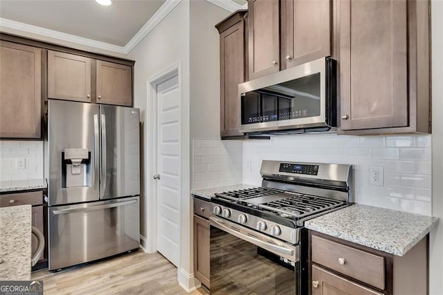 kitchen featuring light stone counters, stainless steel appliances, crown molding, and light hardwood / wood-style flooring