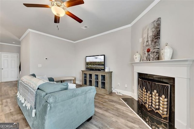 living room featuring hardwood / wood-style flooring, ceiling fan, and ornamental molding