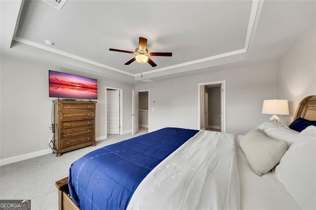 bedroom with carpet floors, a raised ceiling, and ceiling fan