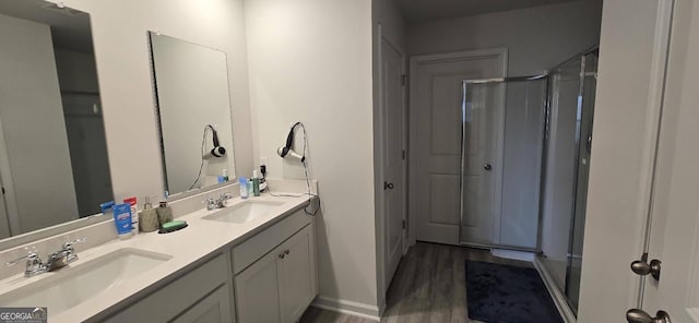 bathroom with hardwood / wood-style flooring, vanity, and a shower with door