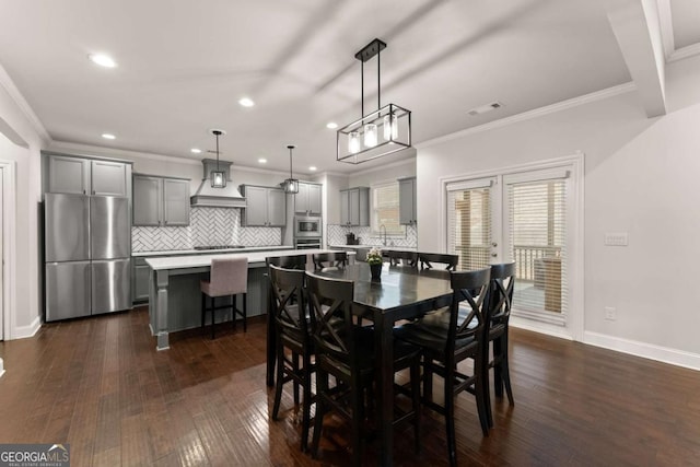 dining room with dark wood-type flooring and ornamental molding