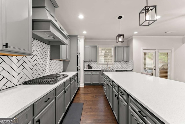6514 Lemon Grass Ln, Flowery Branch, GA 30542 - kitchen featuring gray cabinetry, custom exhaust hood, ornamental molding, stainless steel gas cooktop, and tasteful backsplash