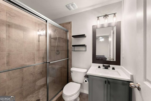 bathroom with vanity, toilet, and a shower with door