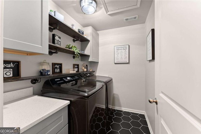 clothes washing area featuring cabinets and washing machine and clothes dryer