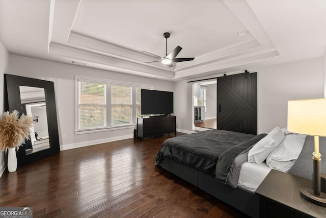 6514 Lemon Grass Ln, Flowery Branch, GA 30542 - bedroom featuring a raised ceiling, a barn door, wood finished floors, crown molding, and a ceiling fan