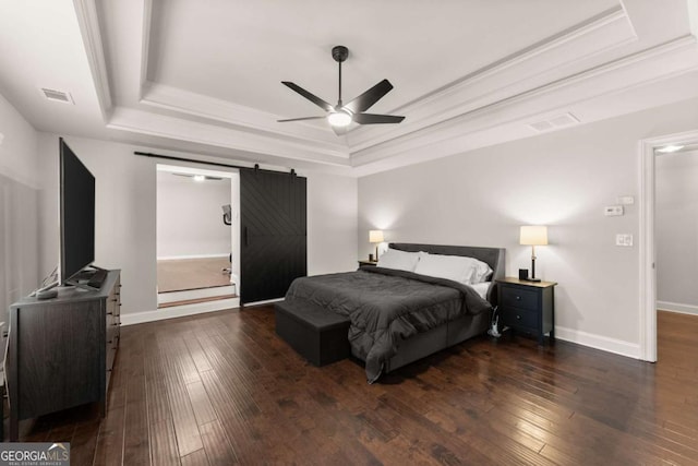 bedroom with dark hardwood / wood-style flooring, ceiling fan, a raised ceiling, crown molding, and a barn door