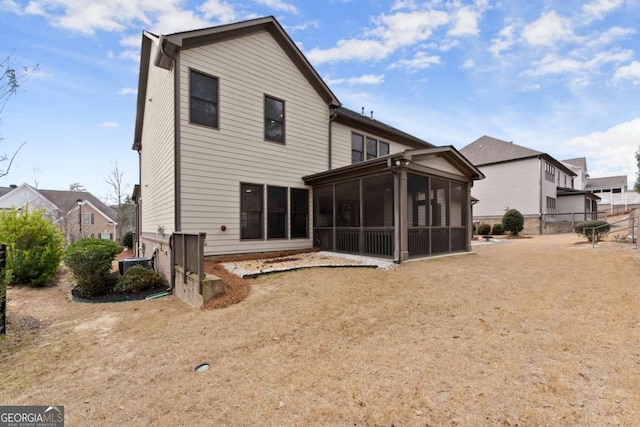 rear view of house featuring a sunroom