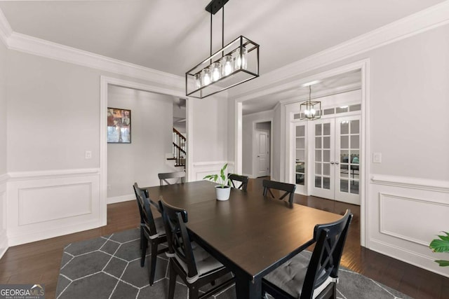 6514 Lemon Grass Ln, Flowery Branch, GA 30542 - dining room featuring stairs, dark wood-style flooring, a chandelier, crown molding, and a decorative wall