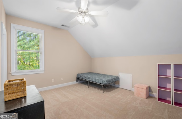 interior space featuring ceiling fan, attic access, vaulted ceiling, carpet floors, and baseboards