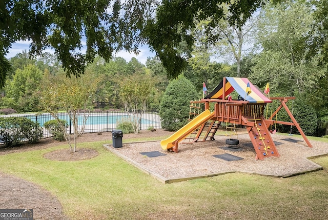 community jungle gym featuring a lawn, fence, and a fenced in pool