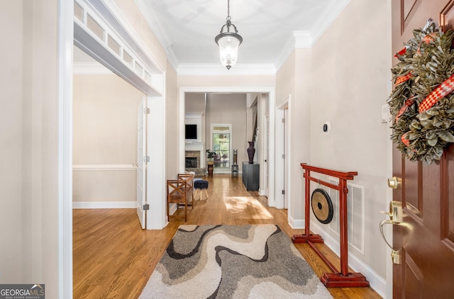 dining space featuring an inviting chandelier, ornamental molding, light wood-style floors, and baseboards