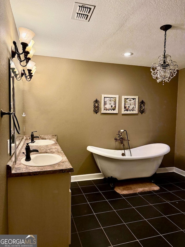 bathroom featuring vanity, a tub to relax in, tile patterned floors, and an inviting chandelier