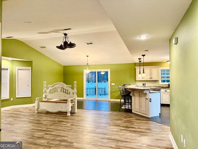 bedroom with hardwood / wood-style flooring, vaulted ceiling, and access to exterior