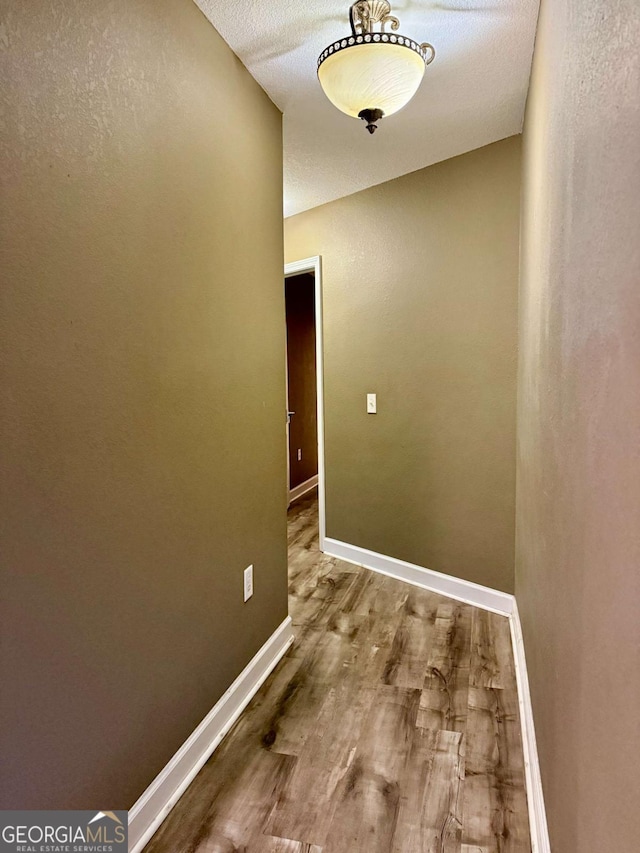 corridor with hardwood / wood-style flooring