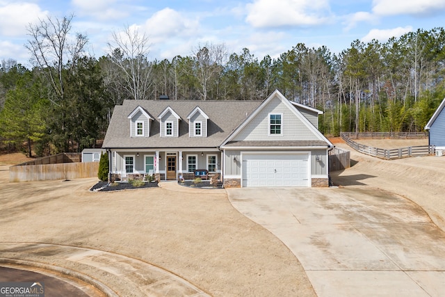 view of front of property featuring roof with shingles, a porch, concrete driveway, an attached garage, and fence