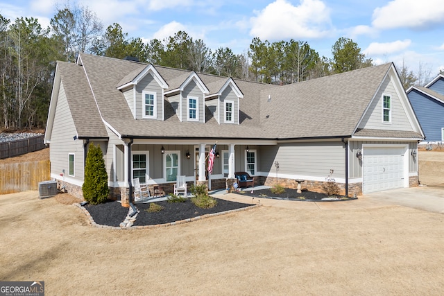 view of front of house with covered porch, a garage, fence, driveway, and roof with shingles