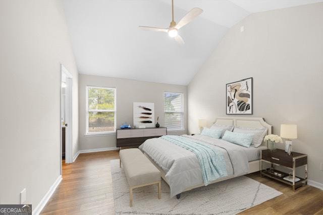 bedroom featuring wood-type flooring, ceiling fan, and high vaulted ceiling