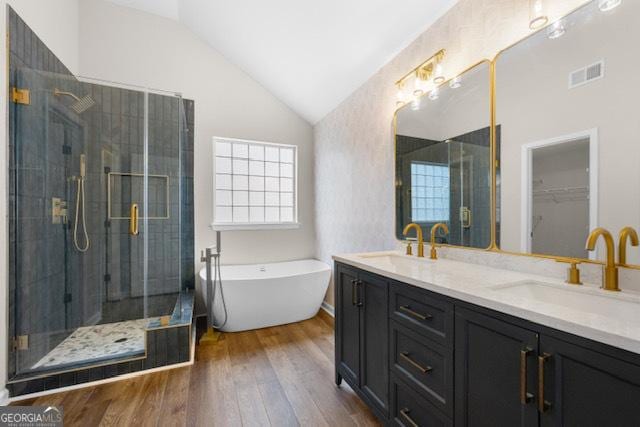 bathroom with vanity, hardwood / wood-style floors, vaulted ceiling, and plus walk in shower