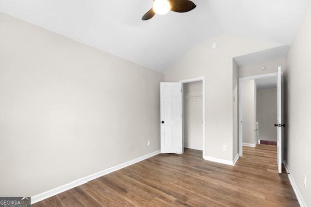 unfurnished bedroom featuring ceiling fan, lofted ceiling, wood-type flooring, and a closet