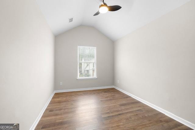 empty room featuring lofted ceiling, dark wood-type flooring, and ceiling fan