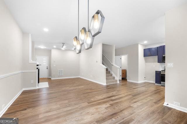 unfurnished living room featuring hardwood / wood-style flooring and a chandelier