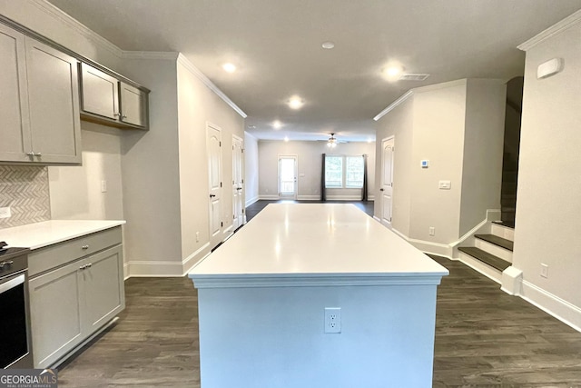 kitchen with gray cabinets, a center island, backsplash, and dark hardwood / wood-style flooring