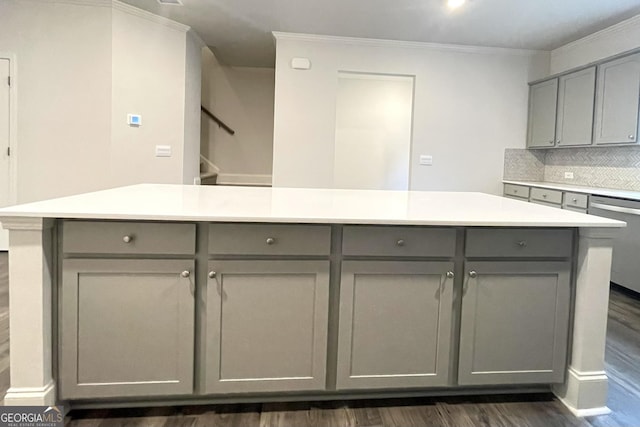 kitchen with gray cabinets, dishwasher, dark wood-type flooring, and crown molding