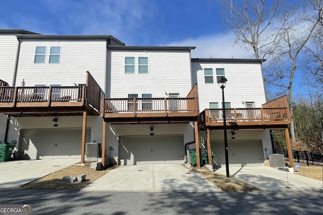 rear view of house featuring a garage and central air condition unit