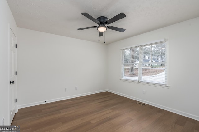 spare room with ceiling fan, dark hardwood / wood-style floors, and a textured ceiling