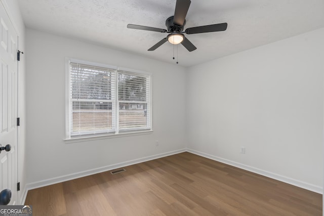 spare room with ceiling fan, hardwood / wood-style flooring, and a textured ceiling