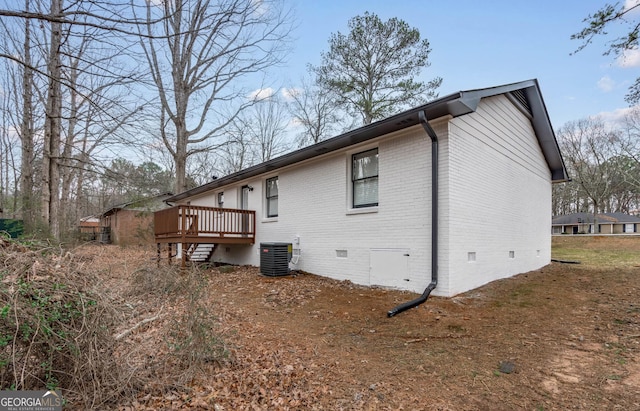 rear view of house featuring a wooden deck and central air condition unit